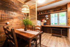 a wooden dining room with a wooden table and chairs at Chata 'Leśne Kurki' in Kurki