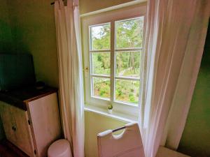 ein Fenster mit einem weißen Vorhang und einem WC in einem Zimmer in der Unterkunft Strandhotel Lindequist in Ostseebad Sellin