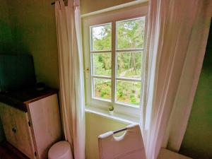 a window with a white curtain and a toilet in a room at Strandhotel Lindequist in Ostseebad Sellin