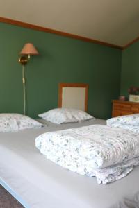 two beds in a bedroom with a green wall at Mauranger Kro & Gjestehus in Bondhus