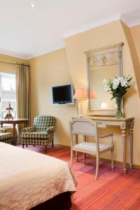 a hotel room with a bed and a desk with a mirror at Martin's Relais in Bruges