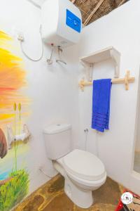 ein Bad mit einem WC und einem blauen Handtuch in der Unterkunft King Lion Room - Watamu in Watamu