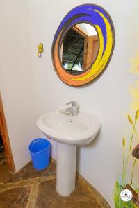 ein Bad mit einem Waschbecken und einem Spiegel in der Unterkunft King Lion Room - Watamu in Watamu