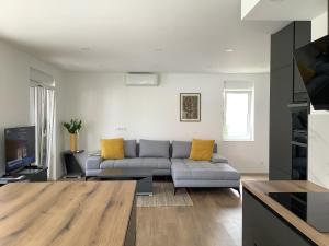 a living room with a gray couch and yellow pillows at Apartments Jozef in Vodice