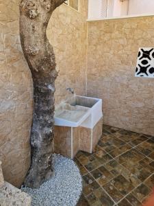 a bathroom with a fake tree next to a sink at Casa Giulia in Denia