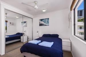 a bedroom with a blue bed and a mirror at Zion Escapes Retreat on Pease, City Edge Family Apartment in Westcourt