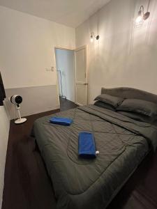 1 dormitorio con 1 cama grande y toallas azules. en sungai ujong home stay, en George Town