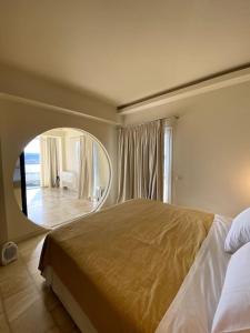a bedroom with a large bed and a mirror at Best View Stylish Penthouse in Corfu Town