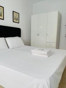 Una cama blanca con un montón de toallas. en Casa Spencer, en Benidorm