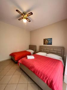 two beds in a bedroom with a ceiling fan at J&B Rooms Dhermi in Dhërmi +27 photos