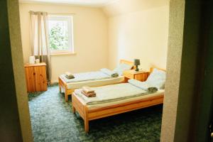 a room with two beds and a window at Beach Bus Hotel in Roja