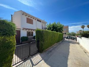 a walkway in front of a house with a hedge at El Xalet d’en Joan Maria d’Altafulla in Altafulla