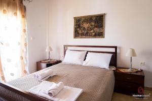 a bedroom with a bed with two towels on it at VILLA ROSSA in Mesimvría