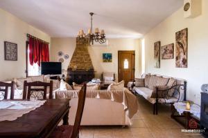 a living room with couches and a table and a fireplace at VILLA ROSSA in Mesimvría