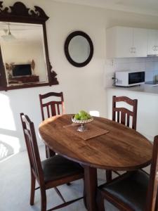 un tavolo di legno con sedie e una ciotola di frutta sopra di Bright Deluxe No.1 TOWNHOUSE ACCOMMODATION a Bright