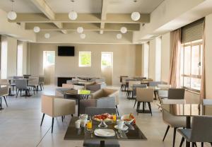 a restaurant with tables and chairs and a television at Pousada A Lanzada in A Lanzada