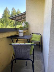 Balcón con 2 sillas, mesa y mesa en Oja 134 Apartments en Pärnu