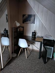 Cette chambre comprend un bureau et deux chaises blanches. dans l'établissement Pokoje Gościnne Grażyna Kozioł, à Zakopane