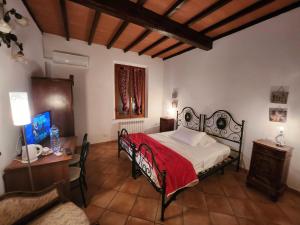 Schlafzimmer mit einem Bett mit einer roten Decke und einem Schreibtisch in der Unterkunft Casa cecchi siena in Siena
