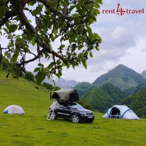 a car parked in a field next to tents at Rent4travel in Tbilisi City