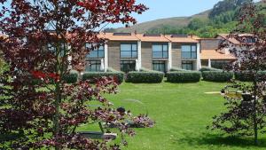 a large building with a yard with trees and grass at Las Villas de Cué in Llanes