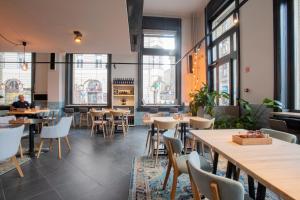 a restaurant with tables and chairs and windows at Modern top floor loft with balcony in Budapest