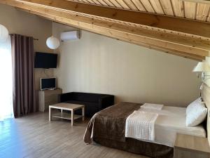 a hotel room with a bed and a tv at Guest house LETTO in Gagra