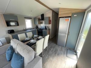 eine Küche und ein Wohnzimmer mit einem Tisch und einem Kühlschrank in der Unterkunft Marine Holiday Park D & S rental A in Rhyl