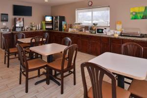 un restaurante con mesas, sillas y una barra en Wingate by Wyndham Beaver I-15, en Beaver