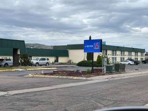 a blue sign in a parking lot next to a building at Motel 6 Pocatello ID in Pocatello