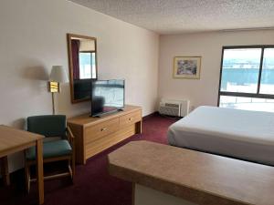 um quarto de hotel com uma cama e uma televisão em Motel 6 Pocatello ID em Pocatello