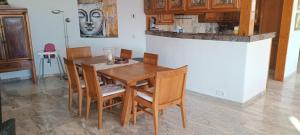 een eetkamer met een houten tafel en stoelen bij ANFI TOPAZ VILLA TAURO GOLF & BEACH 3 bedrooms 4 bathrooms private pool in Mogán