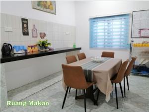 a dining room table and chairs in a kitchen at Kampung Vibe @ Homestay Baiduri in Slim River