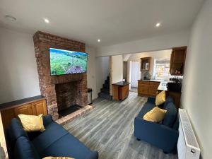 a living room with two blue couches and a fireplace at Newtown Townhouse in Newtown