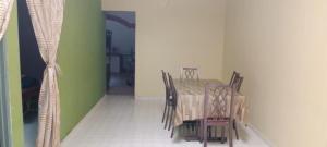 a table and chairs in a room with green walls at BB Bahau Homestay in Bahau