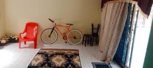 um quarto com uma bicicleta e uma cadeira vermelha em BB Bahau Homestay em Bahau