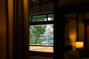 a room with a window with a view of a deck at Greens By Roomy, Kalam in Kalām