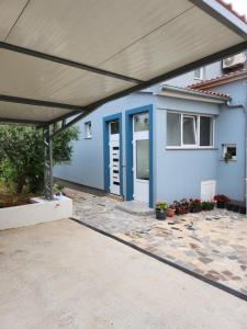 ein blaues Haus mit einer Markise und einer Terrasse in der Unterkunft Apartman Emir in Marčana