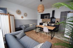 - un salon avec un canapé bleu et une table dans l'établissement La Maison du Bonheur - Lille, à Lille