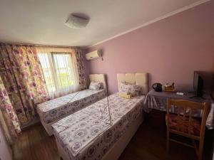 a small room with two beds and a window at Daniel Guest House in Nesebar
