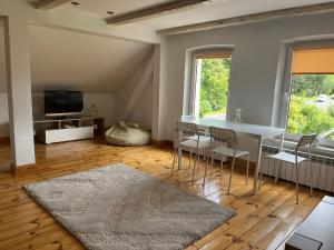 sala de estar con mesa, sillas y TV en Mazurski Dom, en Pisz