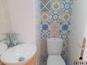 a bathroom with a toilet and a sink and tiles at CASA CARMELA in Cazorla +3 photos