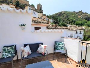 a balcony with a couch and chairs on a building at CASA CARMELA in Cazorla
