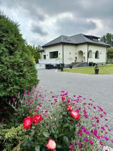 dom z różowymi kwiatami przed nim w obiekcie Nowy Dom Polska w mieście Magnuszew