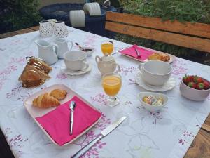 - une table avec petit-déjeuner composé de thé, de croissants et de jus d'orange dans l'établissement Chambre d'hôte des Thermes, à Vichy