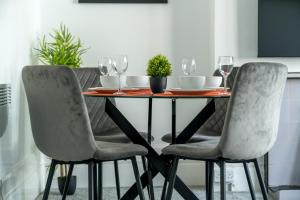 a dining room table with two chairs and wine glasses at Spacious king size 1bed flat in leafy suburb in London