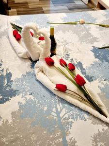 two towel swans with red roses on a table at Apartments Krstos place in Kotor