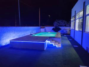 a swimming pool at night next to a building at Alloggio turistico 7 min dall'Aeroporto in Focene
