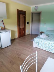 1 dormitorio con 1 cama, 1 silla y 1 reloj en Colori nel Parco 2 en Cesiomaggiore