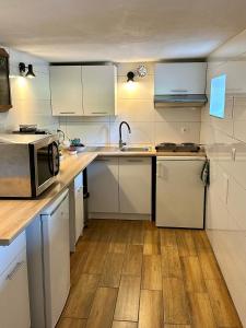 a small kitchen with white cabinets and a microwave at Nowy Dom Polska in Magnuszew